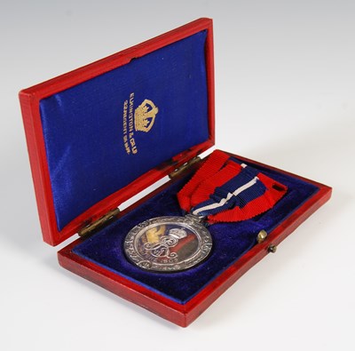Lot 77 - A group of three medals to include red leather...