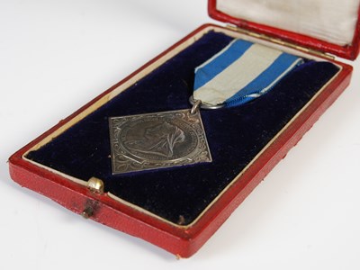 Lot 77 - A group of three medals to include red leather...