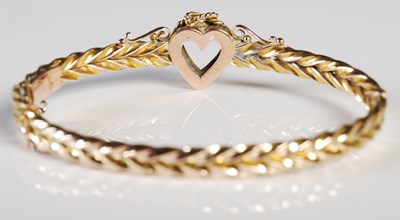 Lot 58 - A yellow metal and split pearl hinged bangle...