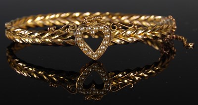 Lot 58 - A yellow metal and split pearl hinged bangle...