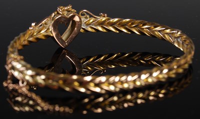 Lot 58 - A yellow metal and split pearl hinged bangle...