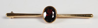 Lot 210 - A 9ct gold and garnet bar brooch, 55.6mm long,...
