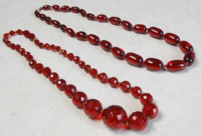 Lot 188 - Two red amber type graduated bead necklaces,...