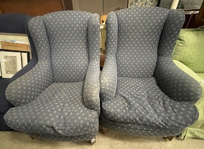Lot 818 - A pair of blue upholstered wing armchairs with...