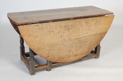 Lot 13 - An antique oak gate-leg dining table, the oval...