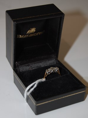 Lot 57 - A yellow and white metal three stone diamond...