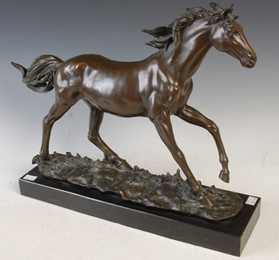 Lot 364 - A bronze figure of a running horse on polished...