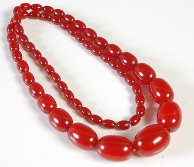 Lot 37 - A red amber type graduated bead necklace, 75...
