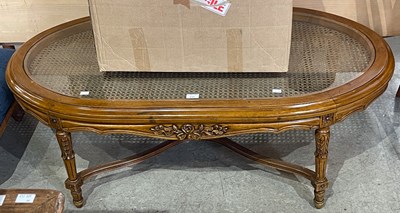 Lot 818 - A stained wood oval coffee table, with glass...
