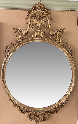 Lot 806 - A mid-century ornate gilt oval mirror with a...