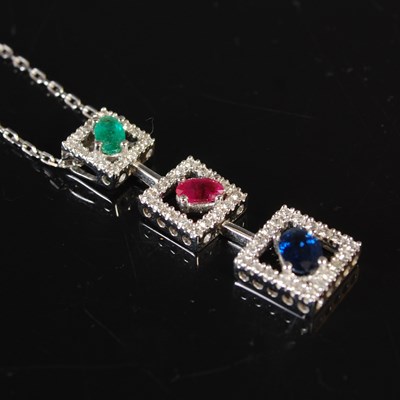 Lot 245 - An 18ct white gold diamond, emerald, ruby, and...