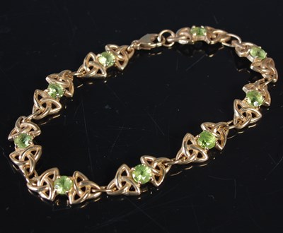 Lot 24 - A yellow metal and green gemstone set Celtic...