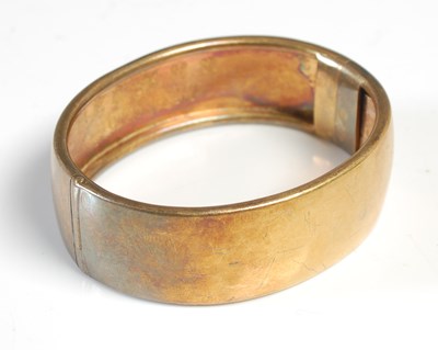 Lot 239 - A late 19th century yellow metal hinged bangle,...