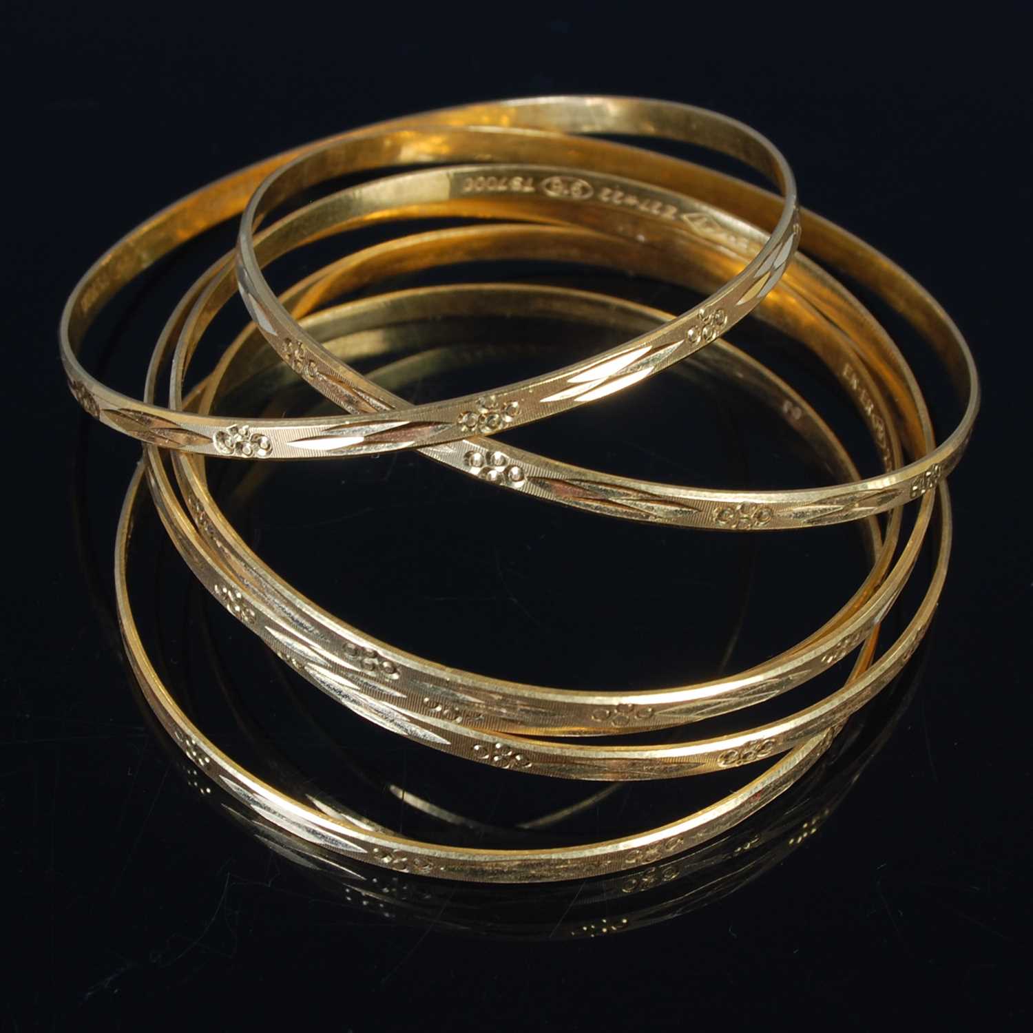 Lot 25 - Six high carat gold bangles, all stamped '22',...