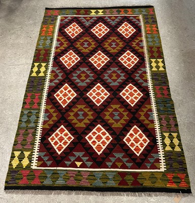 Lot 669 - A Maimana Kilim rug, worked in burgundy, black,...