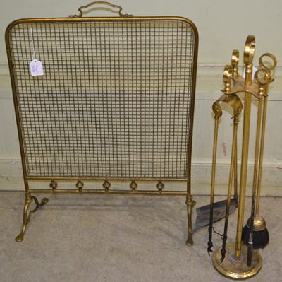 Lot 515 - A brass fireplace companion set, featuring...