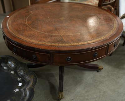 Lot 606 - A reproduction drum table with brown leather...
