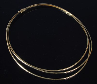 Lot 11 - A triple strand 18ct gold necklace, stamped...