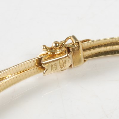 Lot 11 - A triple strand 18ct gold necklace, stamped...