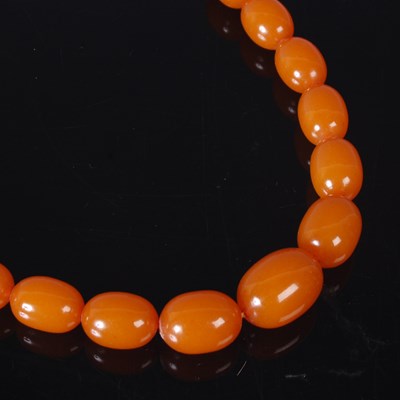 Lot 15B - A graduated amber bead necklace, 79cm long, 81....