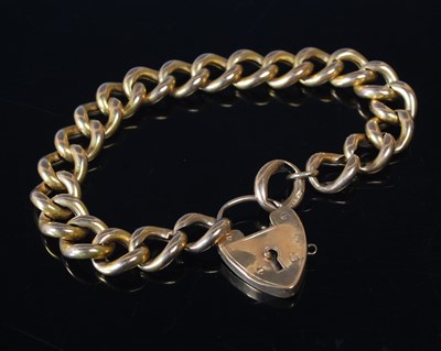 Lot 24 - A gold curb-link bracelet with heart shaped...
