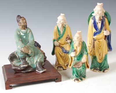 Lot 304 - A Chinese ceramic figure of a scholar seated...