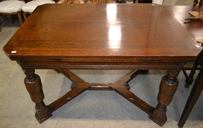 Lot 640 - An early 20th century oak extending dining...