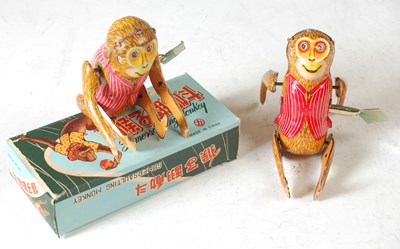 Lot 213 - Two 20th century wind-up monkey tin toys, with...