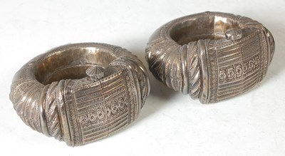Lot 140 - A pair of Omani silver anklets, with chased...