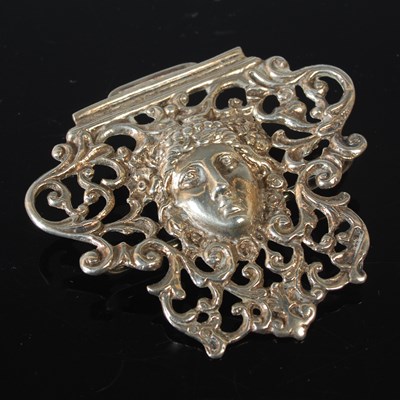 Lot 156 - A silver buckle section, centred with the head...