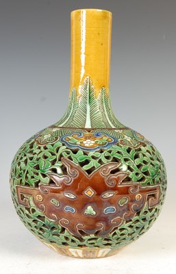 Lot 688 - A Chinese porcelain sancai glazed reticulated double-wall bottle vase, Qing Dynasty