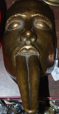 Lot 330 - A bronze model of a face with long...
