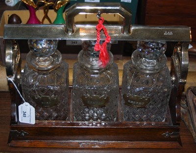 Lot 345 - An oak and EP mounted whisky tantalus with...