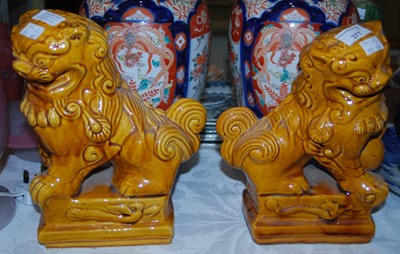 Lot 377 - A pair of Chinese ochre glazed pottery dogs of...