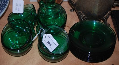 Lot 558 - A set of eight green glass cups and saucers by...