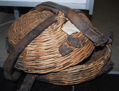 Lot 677 - A circular lidded wicker basket with leather...