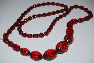 Lot 262 - A red faceted amber type bead necklace, gross...