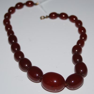 Lot 264 - A vintage red amber type graduated bead...