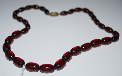 Lot 265 - A red amber type graduated bead necklace,...