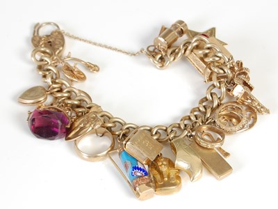 Lot 457 - A 9ct gold charm bracelet, suspending twenty...