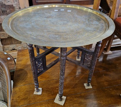 Lot 648 - An Eastern brass and carved wood folding tray...
