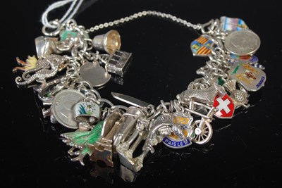 Lot 50 - A silver charm bracelet suspending multiple...