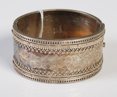 Lot 169 - A hinged white metal bangle with engraved...