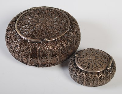 Lot 184 - Two white metal filigree work circular boxes...