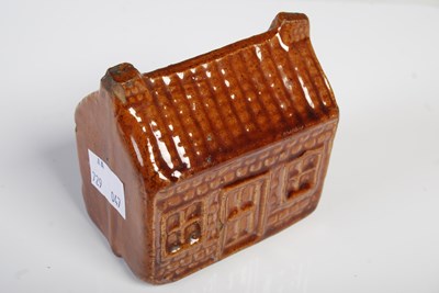 Lot 231 - A Scottish treacle glazed pottery money bank...